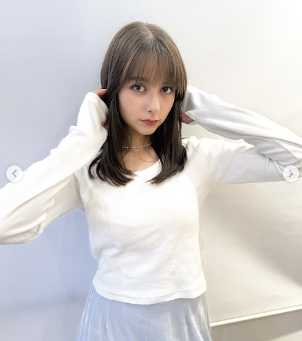 嵐莉菜がカメラ目線で髪に触れる写真