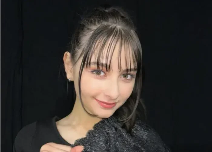黒い背景の前で微笑む嵐莉菜
